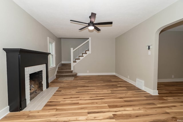 1431 Kilbourn St, Elkhart, IN 46514 - unfurnished living room with a fireplace with flush hearth, light wood-style flooring, stairs, and baseboards