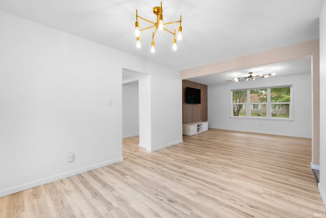 4654 Schmucker Dr, Fort Wayne, IN 46835 - unfurnished living room with a chandelier, light wood-style flooring, and baseboards