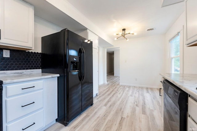 4654 Schmucker Dr, Fort Wayne, IN 46835 - kitchen with black appliances, white cabinetry, light wood-style flooring, a chandelier, and decorative backsplash