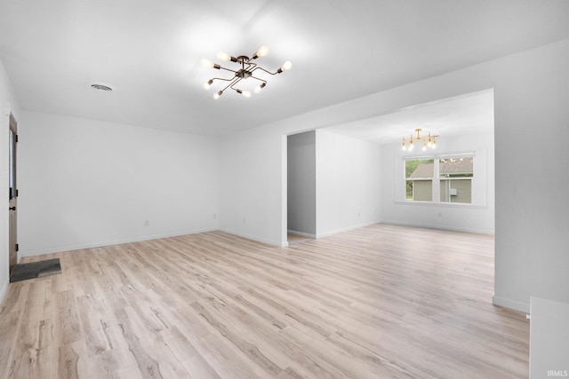 4654 Schmucker Dr, Fort Wayne, IN 46835 - unfurnished living room with a chandelier, light wood finished floors, and baseboards