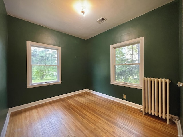 5425 Lincoln Ave, Evansville, IN 47715 - empty room featuring radiator heating unit, healthy amount of natural light, wood finished floors, and baseboards