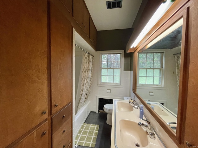 5425 Lincoln Ave, Evansville, IN 47715 - full bath featuring toilet, tile walls, shower / bath combo, double vanity, and a wainscoted wall