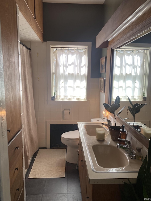 5425 Lincoln Ave, Evansville, IN 47715 - bathroom with healthy amount of natural light, toilet, tile walls, tile patterned floors, and double vanity