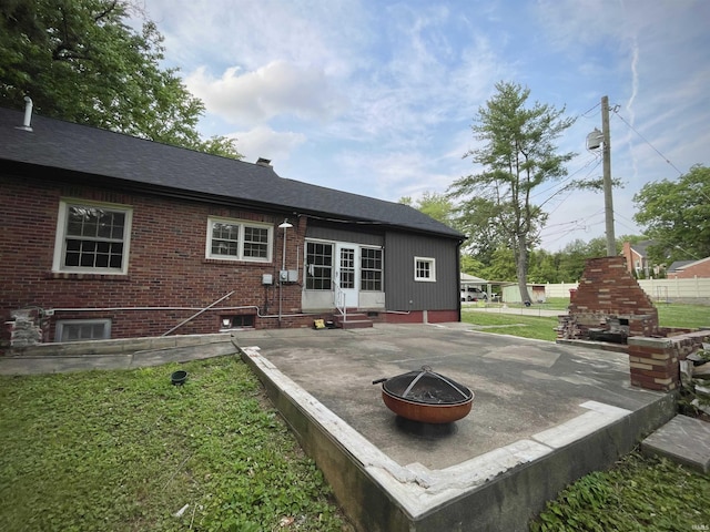 5425 Lincoln Ave, Evansville, IN 47715 - rear view of house featuring a fireplace, a patio area, entry steps, an outdoor fire pit, and brick siding