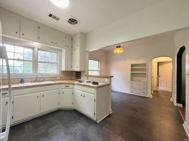 5425 Lincoln Ave, Evansville, IN 47715 - kitchen featuring a sink, a peninsula, arched walkways, white cabinets, and light countertops