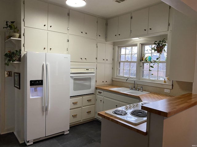 5425 Lincoln Ave, Evansville, IN 47715 - kitchen featuring white appliances, a sink, a peninsula, and white cabinetry