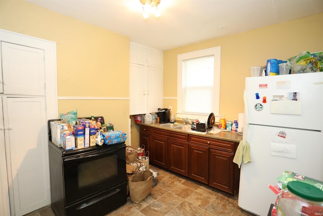 210 14th St, Logansport, IN 46947 - kitchen featuring freestanding refrigerator, a sink, light countertops, and black / electric stove