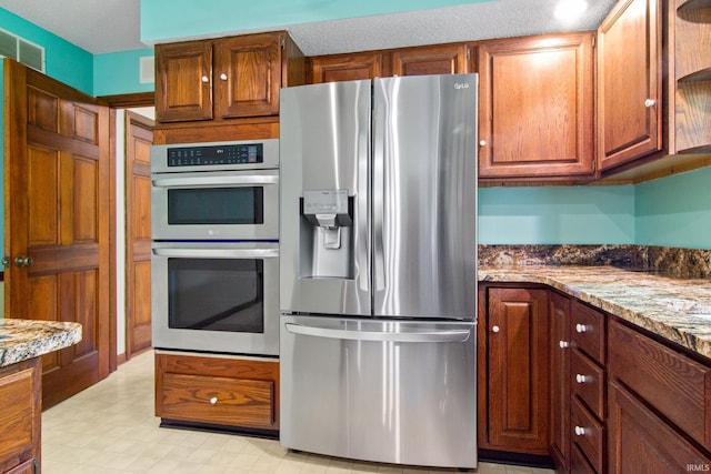 2299 Brown Chapel Rd, Boonville, IN 47601 - kitchen featuring appliances with stainless steel finishes, light stone countertops, light floors, and brown cabinets