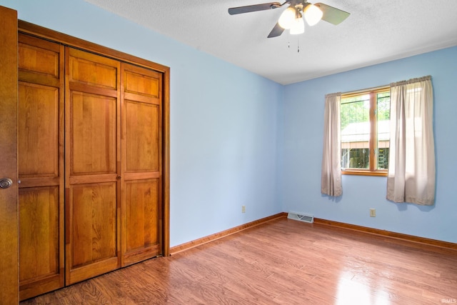 2299 Brown Chapel Rd, Boonville, IN 47601 - unfurnished bedroom featuring light wood-type flooring, baseboards, a closet, ceiling fan, and a textured ceiling