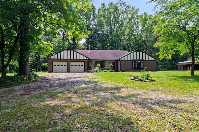 2299 Brown Chapel Rd, Boonville, IN 47601 - tudor home featuring an attached garage, a front lawn, driveway, and brick siding