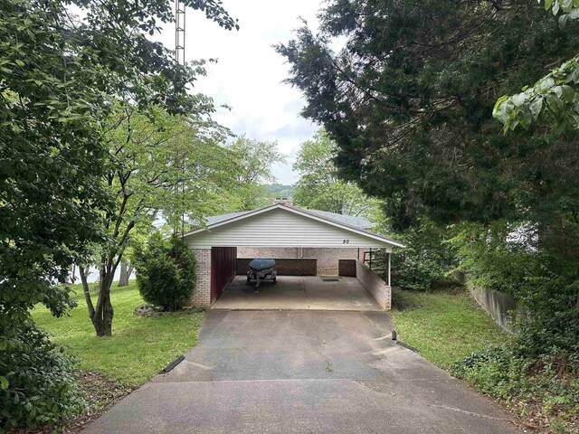 50 Reindeer Cir, Santa Claus, IN 47579 - view of front of home with a front lawn, asphalt driveway, an attached carport, and brick siding
