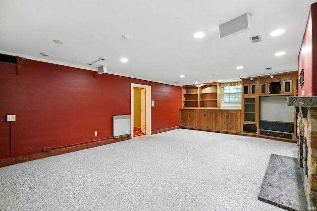 2307 Forest Park Blvd, Fort Wayne, IN 46805 - unfurnished living room with radiator, carpet floors, recessed lighting, a stone fireplace, and crown molding