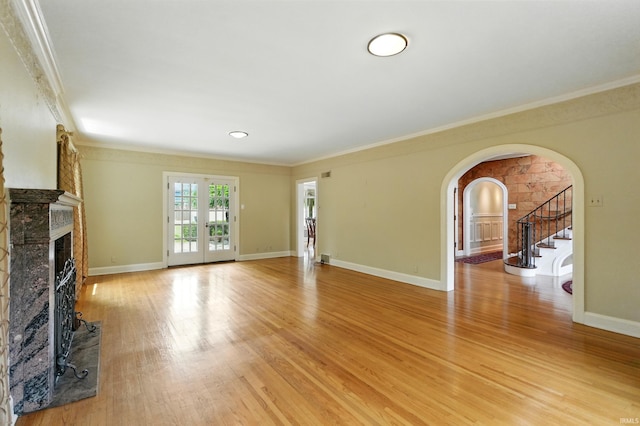2307 Forest Park Blvd, Fort Wayne, IN 46805 - unfurnished living room with arched walkways, a premium fireplace, light wood-style floors, crown molding, and stairway