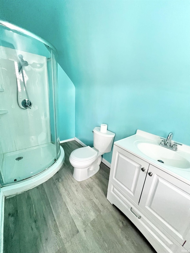 83 9th St, Logansport, IN 46947 - full bathroom with a stall shower, toilet, vanity, baseboards, and wood finished floors
