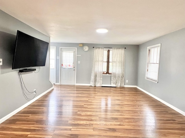 83 9th St, Logansport, IN 46947 - unfurnished living room with healthy amount of natural light, wood finished floors, and baseboards