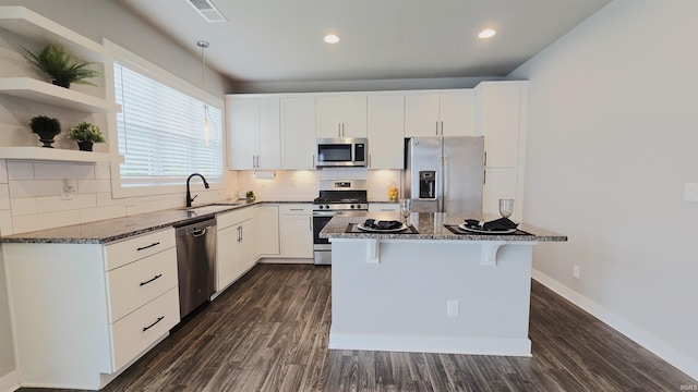 916 Cameo Dr, Evansville, IN 47711 - kitchen with appliances with stainless steel finishes, a sink, dark stone countertops, a kitchen breakfast bar, and dark wood-style flooring