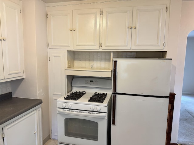 539 Goshen Ave, Elkhart, IN 46516 - kitchen featuring white appliances, white cabinets, dark countertops, and arched walkways