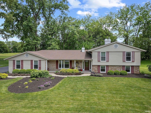 3709 Capilano Dr, West Lafayette, IN 47906 - split level home with a chimney, brick siding, and a front yard