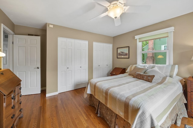 3709 Capilano Dr, West Lafayette, IN 47906 - bedroom featuring two closets, wood finished floors, a ceiling fan, and baseboards
