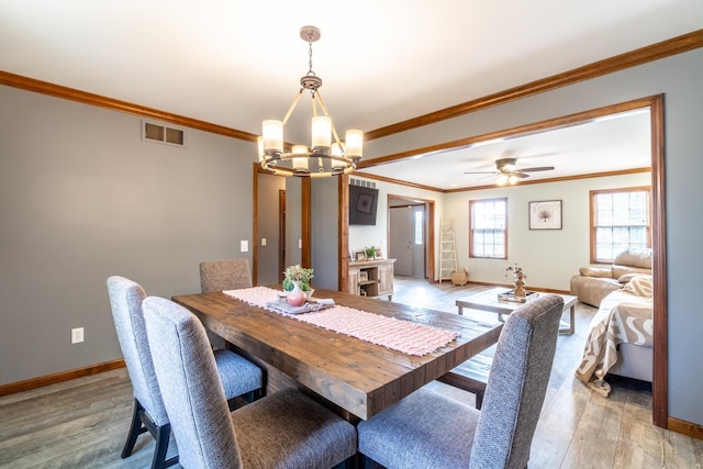 10909 Bittersweet Dells Ln, Fort Wayne, IN 46814 - dining room with a chandelier, ornamental molding, baseboards, light wood-type flooring, and a ceiling fan