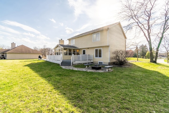 10909 Bittersweet Dells Ln, Fort Wayne, IN 46814 - rear view of house featuring a sunroom, an outdoor fire pit, a lawn, and a wooden deck