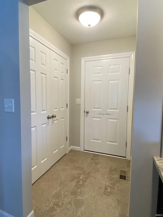 4310 E Duffy Dr, Syracuse, IN 46567 - doorway to outside featuring a textured ceiling and baseboards