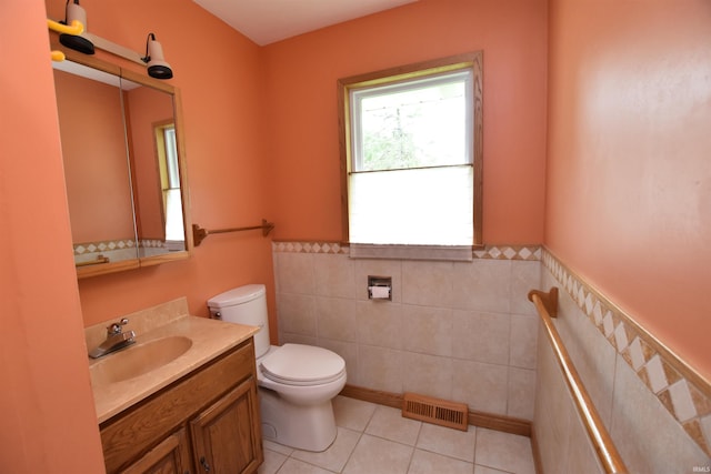1200 S Longwood Dr, Bloomington, IN 47401 - bathroom featuring toilet, tile walls, vanity, tile patterned flooring, and a wainscoted wall