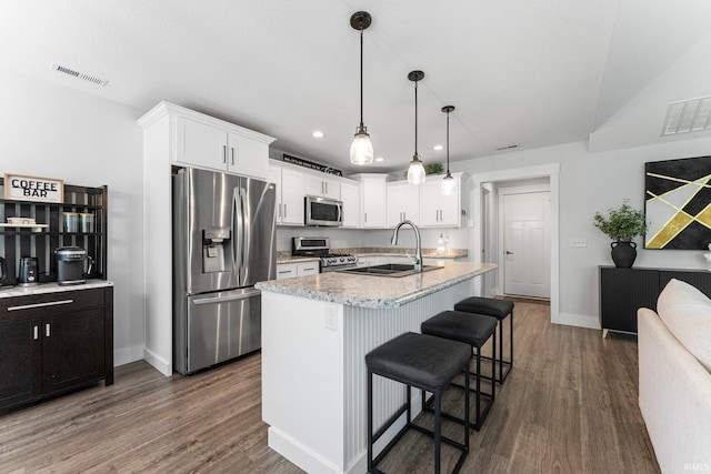 16995 Hatstick Ct, Fort Wayne, IN 46845 - kitchen with appliances with stainless steel finishes, a sink, white cabinetry, dark wood-type flooring, and a kitchen bar