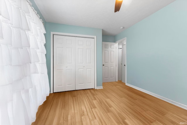 5405 N Andrea Dr, Bloomington, IN 47404 - unfurnished bedroom with baseboards, light wood finished floors, a closet, and ceiling fan