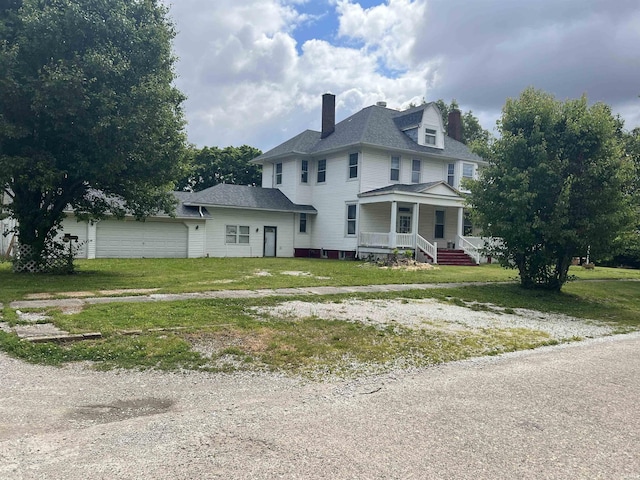102 W Hackett St, Carlisle, IN 47838 - view of side of property featuring covered porch, a chimney, a garage, and a yard