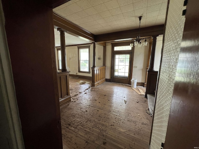 102 W Hackett St, Carlisle, IN 47838 - doorway to outside with decorative columns, wood-type flooring, a chandelier, and baseboards