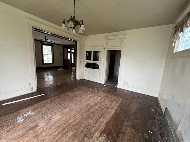 102 W Hackett St, Carlisle, IN 47838 - unfurnished dining area with a chandelier, wood-type flooring, plenty of natural light, and baseboards