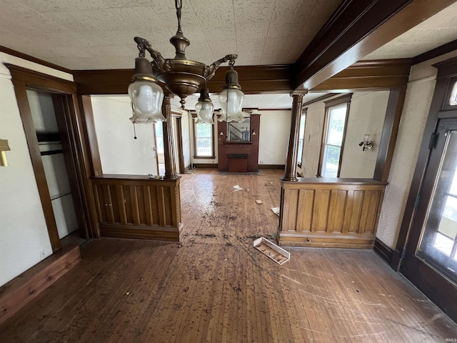 102 W Hackett St, Carlisle, IN 47838 - unfurnished dining area with a chandelier, hardwood / wood-style floors, ornate columns, baseboards, and ornamental molding