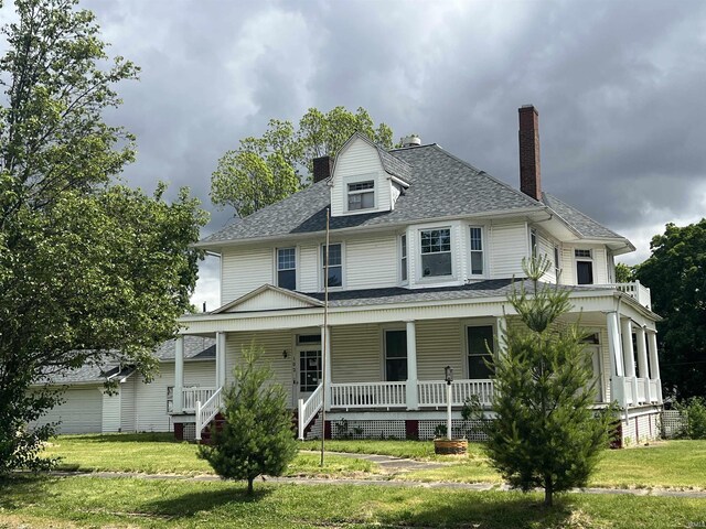 102 W Hackett St, Carlisle, IN 47838 - view of front of home with covered porch, a front lawn, a chimney, and roof with shingles