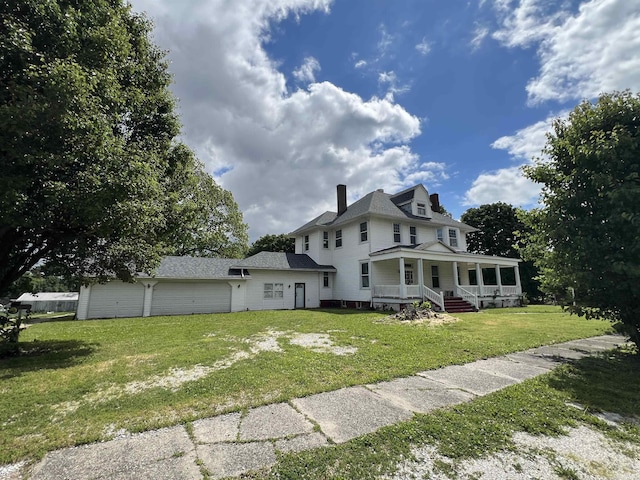 102 W Hackett St, Carlisle, IN 47838 - view of front of house featuring a porch, a front yard, a chimney, an attached garage, and driveway