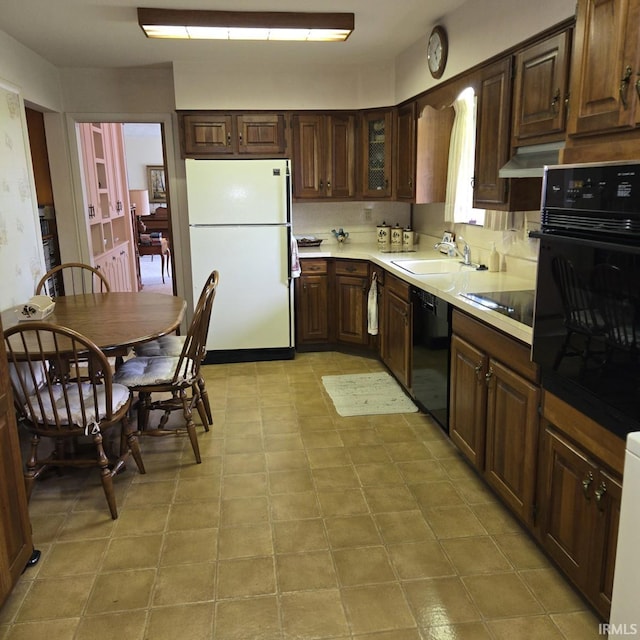 17295 Willowbrook St, South Bend, IN 46635 - kitchen featuring black appliances, light countertops, a sink, glass insert cabinets, and under cabinet range hood