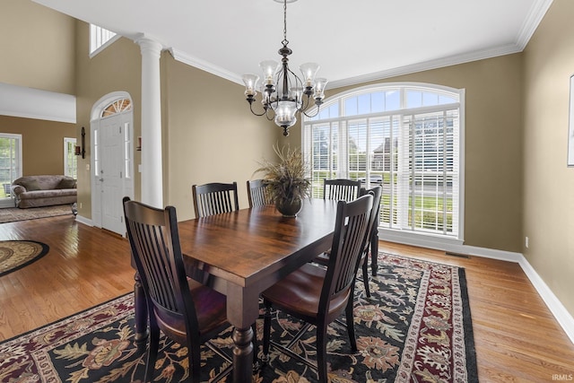3 Brownstone Ct, Jasper, IN 47546 - dining room featuring a chandelier, baseboards, wood finished floors, ornamental molding, and decorative columns