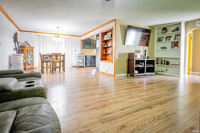 6613 E Hickory Ln, Muncie, IN 47303 - living area featuring ornamental molding, built in features, a chandelier, wood finished floors, and arched walkways