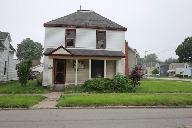 744 First St, Huntington, IN 46750 - view of front of property with covered porch, a shingled roof, and a front lawn