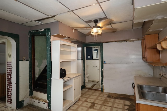 744 First St, Huntington, IN 46750 - kitchen featuring open shelves, a sink, light flooring, ceiling fan, and arched walkways
