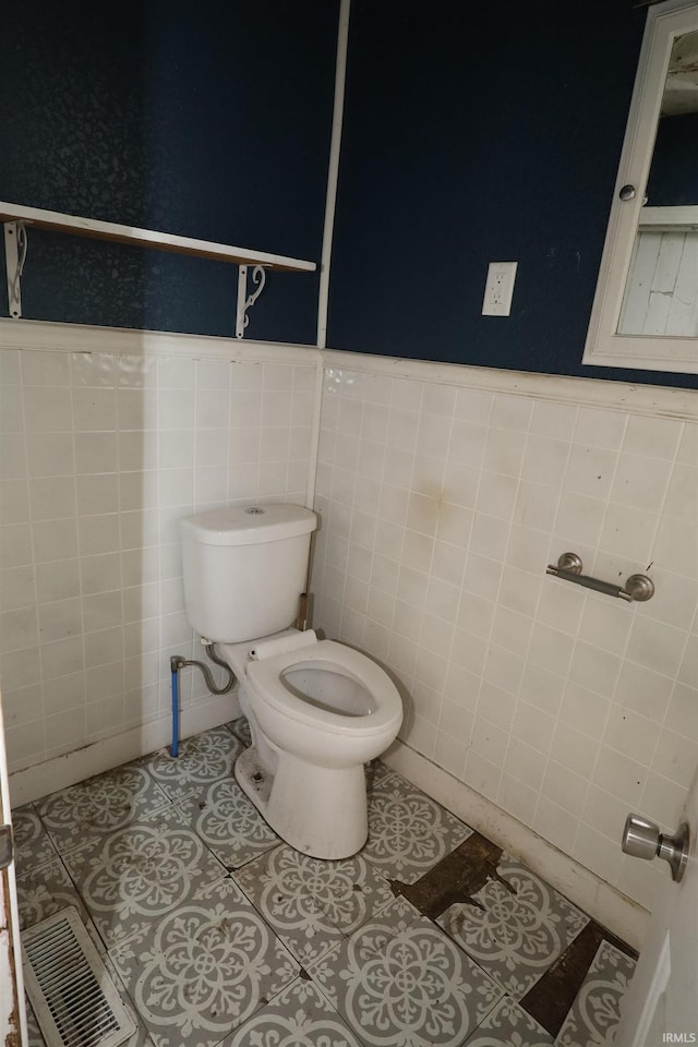 744 First St, Huntington, IN 46750 - half bath featuring toilet, tile walls, a wainscoted wall, and tile patterned flooring