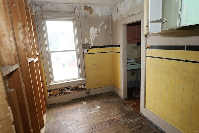 744 First St, Huntington, IN 46750 - empty room with dark wood-style flooring, wainscoting, and tile walls