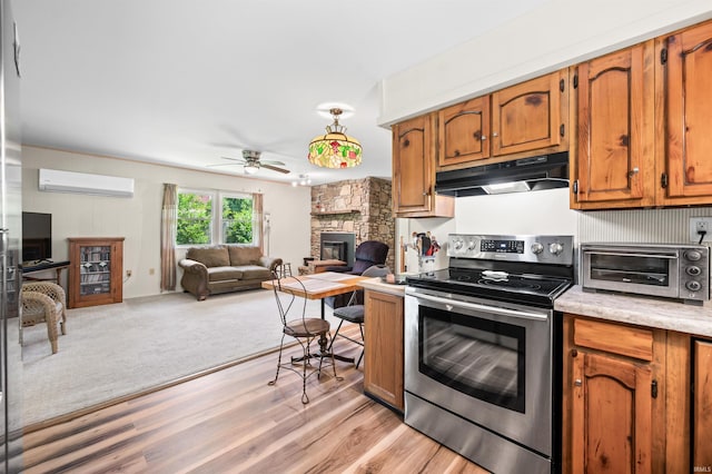 6521 Snug Harbour Ln, Unionville, IN 47468 - kitchen featuring stainless steel electric range oven, under cabinet range hood, a wall unit AC, light countertops, and ceiling fan