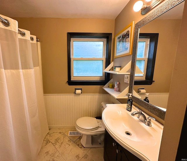 302 S Edgewood Dr, Ellettsville, IN 47429 - bathroom with a wainscoted wall, plenty of natural light, marble finish floors, toilet, and vanity