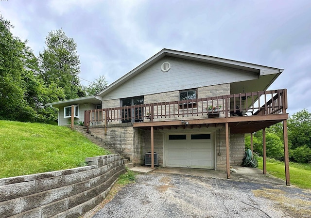 302 S Edgewood Dr, Ellettsville, IN 47429 - view of front of home with a garage, central AC unit, asphalt driveway, a front lawn, and a wooden deck