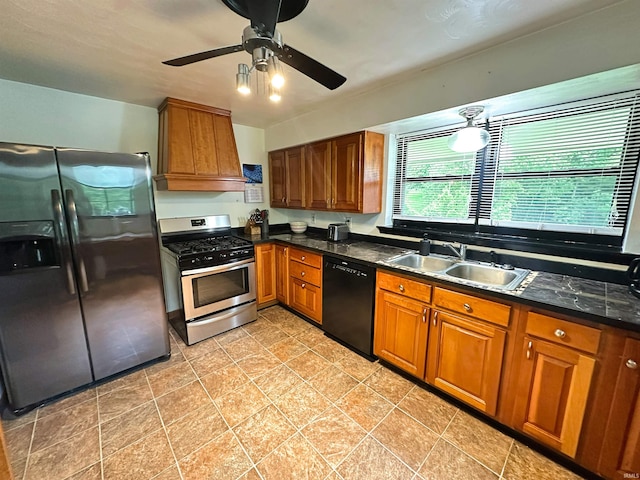 302 S Edgewood Dr, Ellettsville, IN 47429 - kitchen featuring appliances with stainless steel finishes, a sink, brown cabinetry, ceiling fan, and dark stone countertops