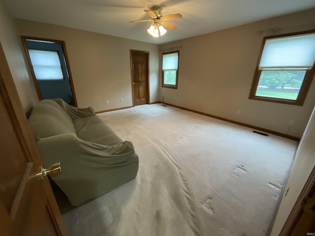 404 Ridge Ct, Ossian, IN 46777 - unfurnished living room featuring baseboards, light colored carpet, and ceiling fan