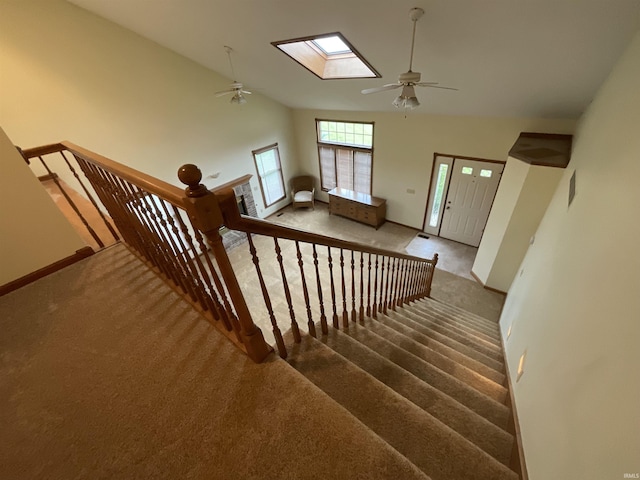 404 Ridge Ct, Ossian, IN 46777 - stairway with a ceiling fan, carpet floors, a skylight, baseboards, and high vaulted ceiling