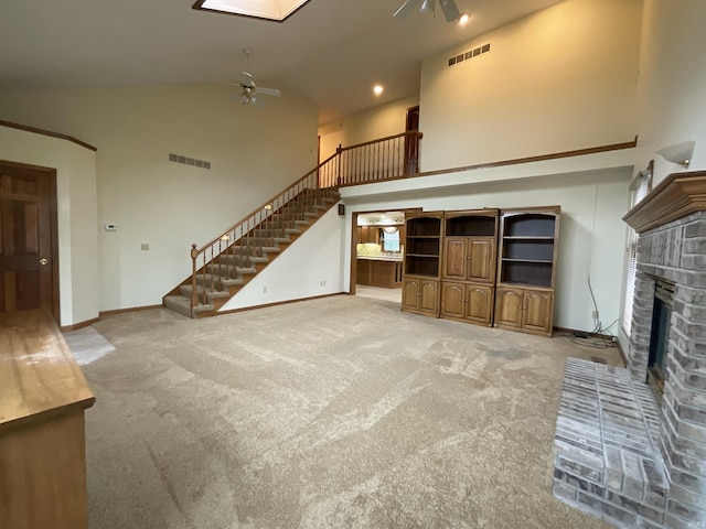 404 Ridge Ct, Ossian, IN 46777 - unfurnished living room with a ceiling fan, high vaulted ceiling, stairs, light carpet, and a fireplace
