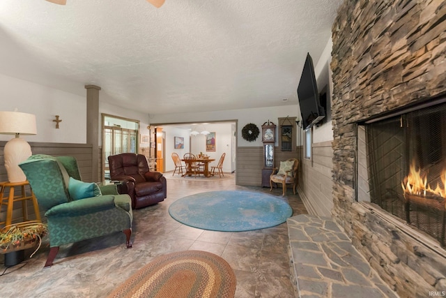 2905 E Mowrey Rd, Columbia City, IN 46725 - living area featuring a lit fireplace, wainscoting, a textured ceiling, and tile patterned flooring